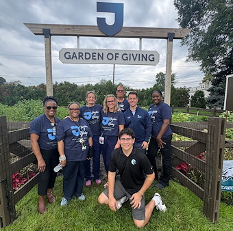 This image shows a photo of eight Jefferson Frankford Hospital employees at the entrance to the Garden of Giving.